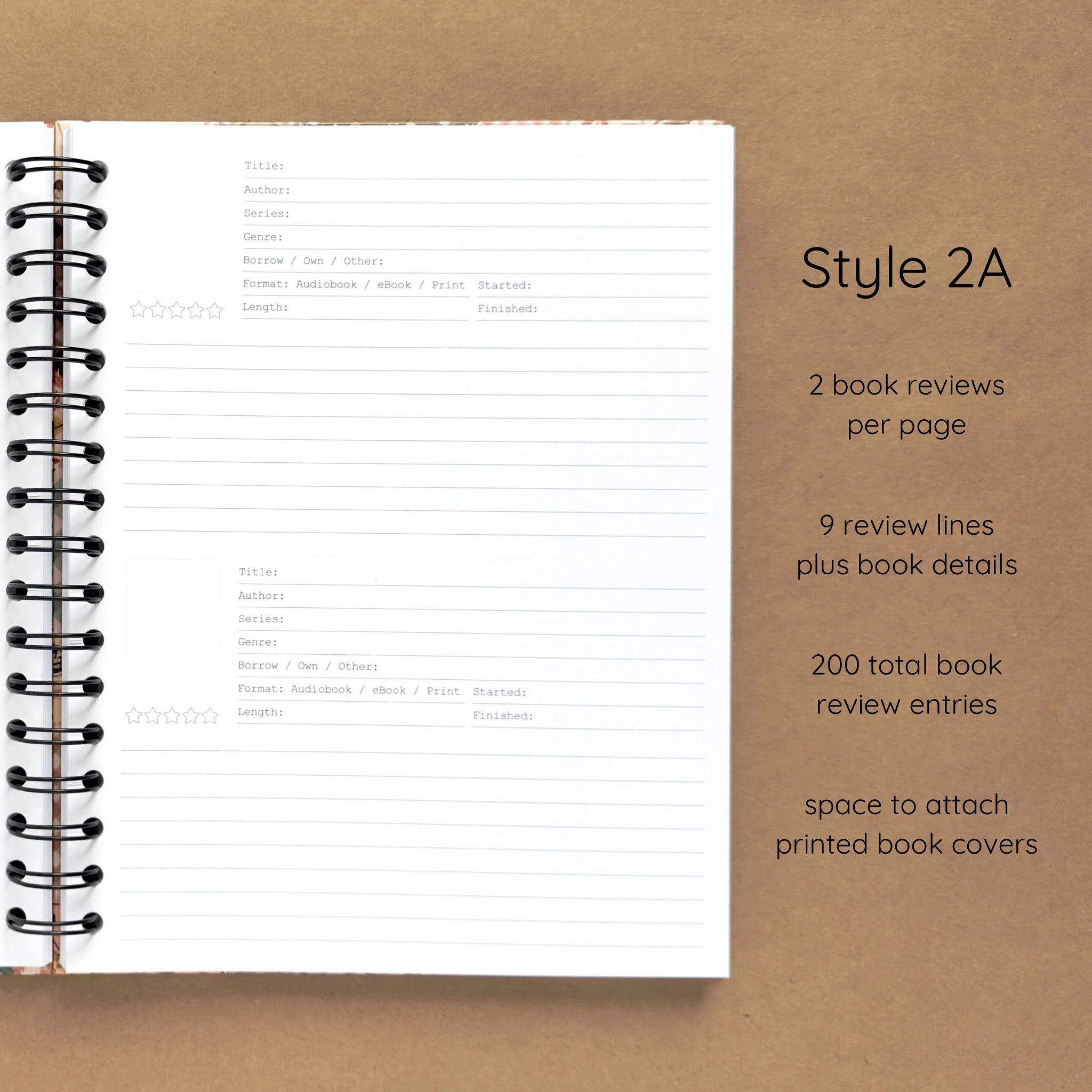 Open spiral-bound hardcover reading journal notebook showing review template option Style 2A featuring two book reviews per page and nine review lines plus book details per review with space to attach printed book covers, displayed on a brown background