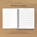 Open spiral-bound softcover reading journal notebook showing daily and weekly reading trackers on a brown background