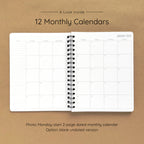 Open spiral-bound softcover reading journal notebook showing monthly calendar pages on a brown background