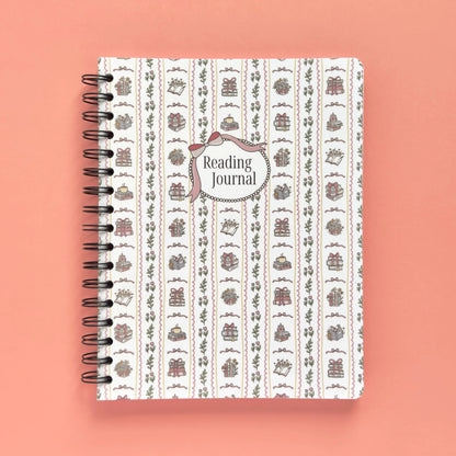 Spiral-bound softcover reading journal notebook with books and bows coquette cover design on a peach background