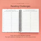 Open spiral-bound hardcover reading journal notebook showing alphabet reading challenges on a peach background