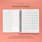 Open spiral-bound softcover reading journal notebook showing daily and weekly reading trackers on a peach background