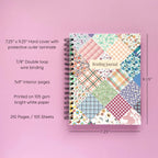 Spiral-bound hardcover reading journal notebook with floral patchwork cover design on a lavender background, featuring details and dimensions