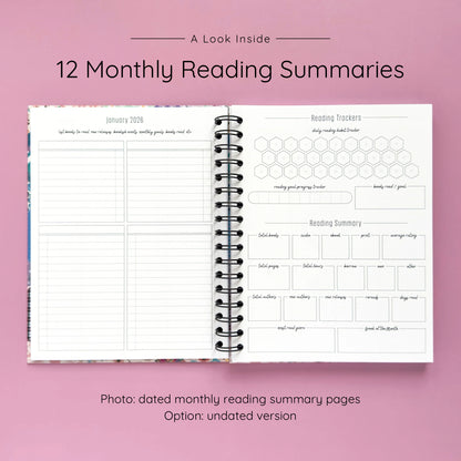 Open spiral-bound hardcover reading journal notebook showing monthly reading summary pages on a lavender background