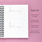 Open spiral-bound hardcover reading journal notebook showing review template option Style 2A featuring two book reviews per page and nine review lines plus book details per review with space to attach printed book covers, displayed on a lavender background