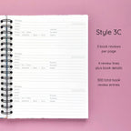 Open spiral-bound hardcover reading journal notebook showing review template option Style 3C featuring three book reviews per page and four review lines plus book details per review, displayed on a lavender background