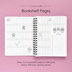 Open spiral-bound softcover reading journal notebook showing bookshelf pages design on a lavender background