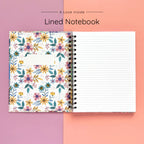 Open spiral-bound softcover lined notebook showing lined notes pages on a yellow and orange background, featuring white wire binding