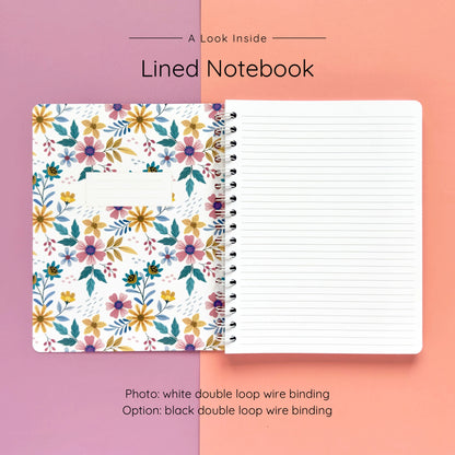 Open spiral-bound softcover lined notebook showing lined notes pages on a lavender and peach background, featuring white wire binding