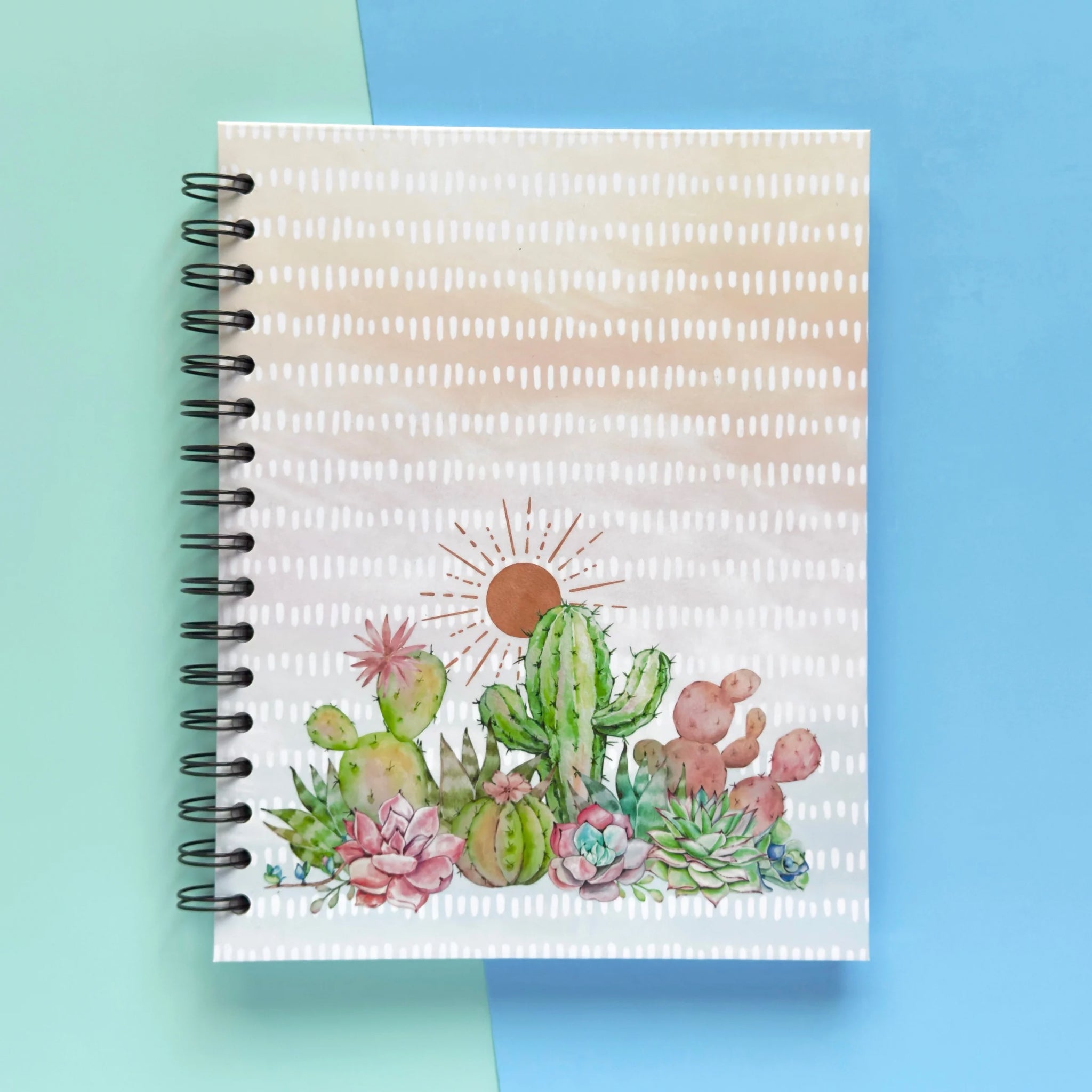 Spiral-bound hardcover lined notebook with cactus and succulent cover design on a teal and blue background