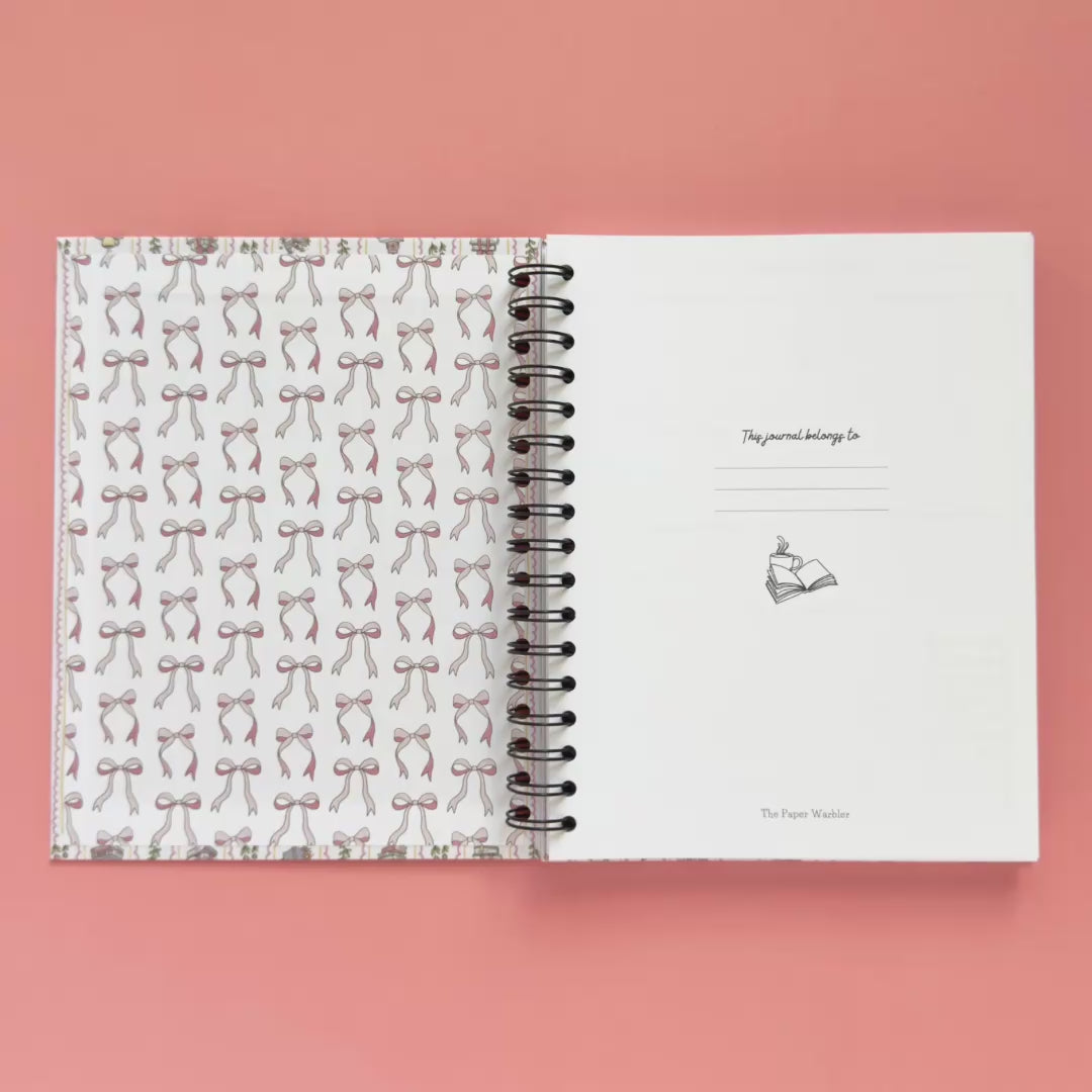 Spiral-bound hardcover reading journal flip through video with books and bows coquette cover design on peach background