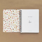 Spiral-bound softcover reading journal flip through video with autumn patchwork cover design on brown background