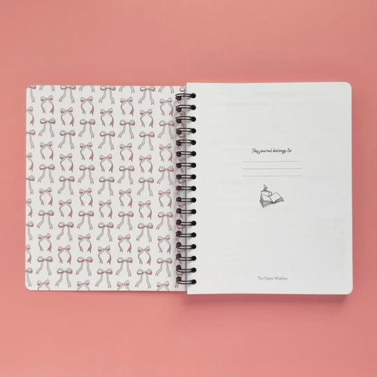 Spiral-bound softcover reading journal flip through video with books and bows coquette cover design on peach background